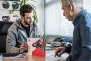 salesman talking with a client at his desk